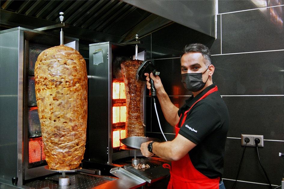 Le chef d'Antalya Snack découpant le döner